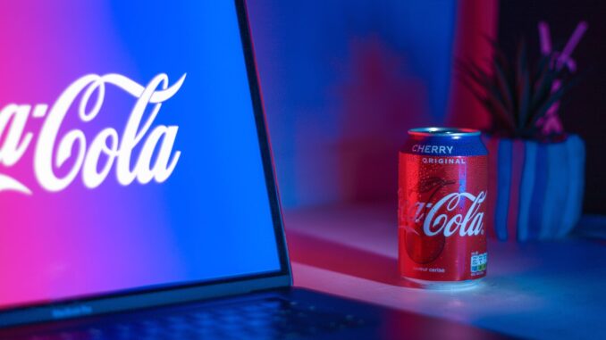 Coca-Cola soda can beside laptop